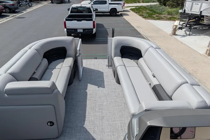 Slide: The Image of 2026 Sun Tracker Party Barge 20 DLX with spacious seating in a parking lot. - 8