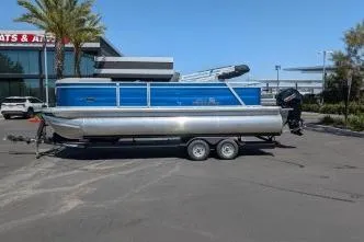The Image of 2026 Sun Tracker Party Barge 22 RF XP3 pontoon boat on trailer in parking lot. - 0