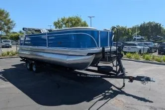 Slide: The Image of 2026 Sun Tracker Party Barge 22 RF XP3 pontoon boat on trailer in parking lot. - 2