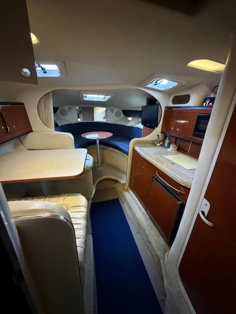 Slide: The Image of Interior of a 2001 Sea Ray 290 Sundancer yacht with kitchen and seating area. - 17