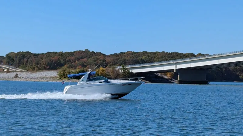 Slide: The Image of 2001 Sea Ray 290 Sundancer cruising under bridge on lake. - 3