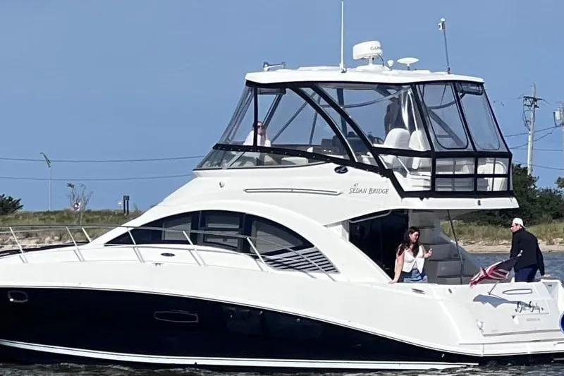 The Image of 2008 Sea Ray 47 Sedan Bridge yacht cruising near shoreline. - 0