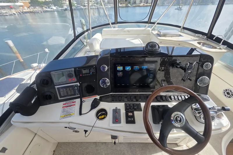 Slide: The Image of 2008 Sea Ray 47 Sedan Bridge helm with navigation controls and steering wheel. - 10