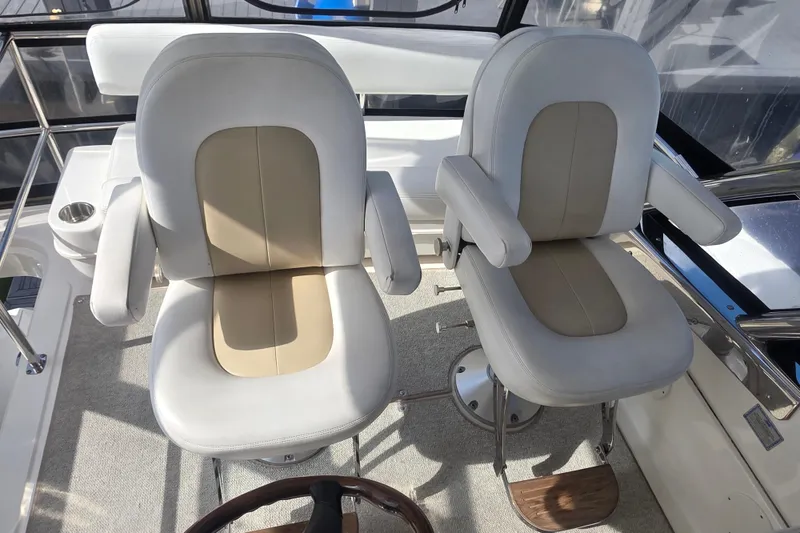 Slide: The Image of Captain's chairs on 2008 Sea Ray 47 Sedan Bridge yacht, featuring beige and white upholstery. - 13