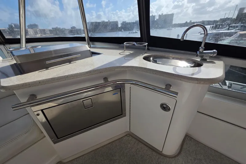 Slide: The Image of Luxurious 2008 Sea Ray 47 Sedan Bridge yacht interior with sleek kitchenette and scenic window view. - 17