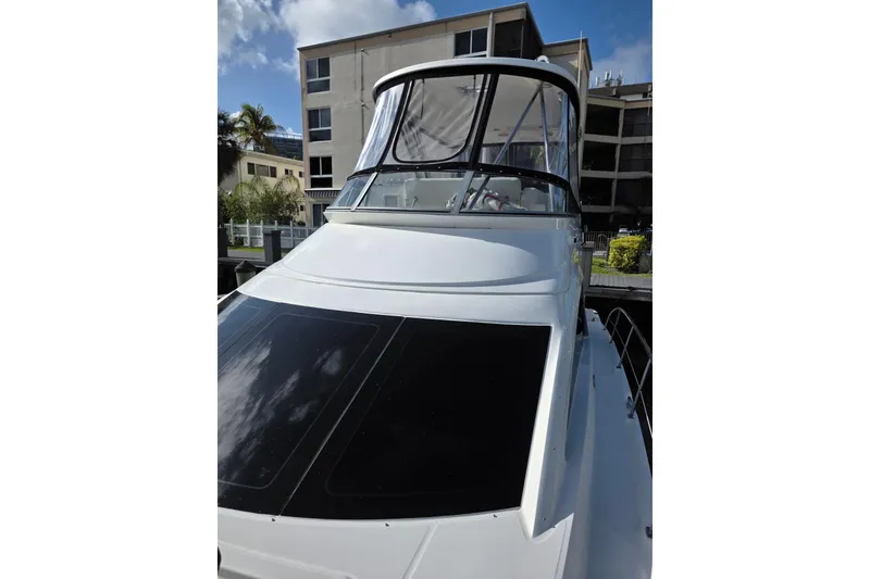 Slide: The Image of 2008 Sea Ray 47 Sedan Bridge yacht docked near residential buildings. - 2