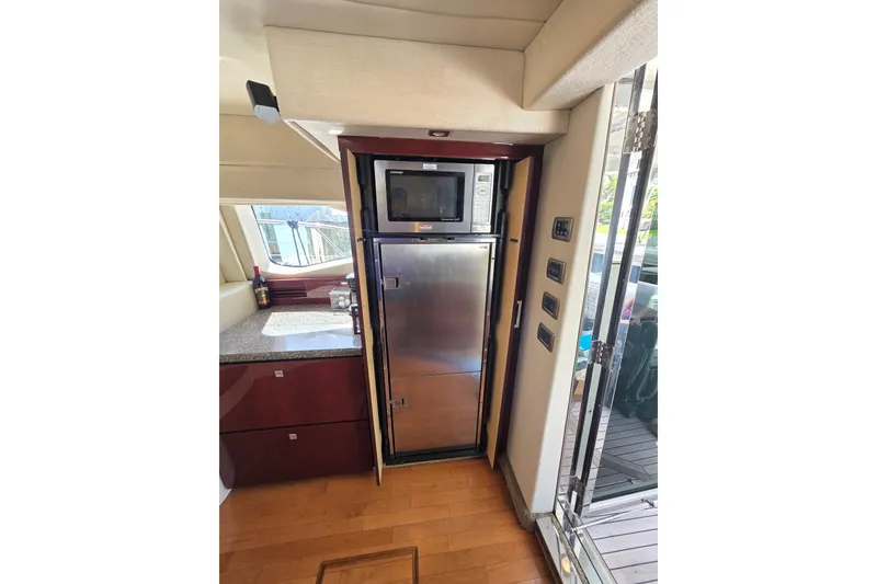 Slide: The Image of 2008 Sea Ray 47 Sedan Bridge yacht kitchen with stainless steel appliances and wooden flooring. - 23