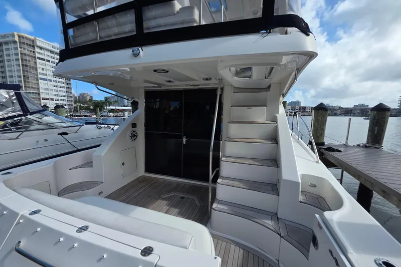 Slide: The Image of 2008 Sea Ray 47 Sedan Bridge yacht docked, featuring spacious deck and elegant staircase. - 7
