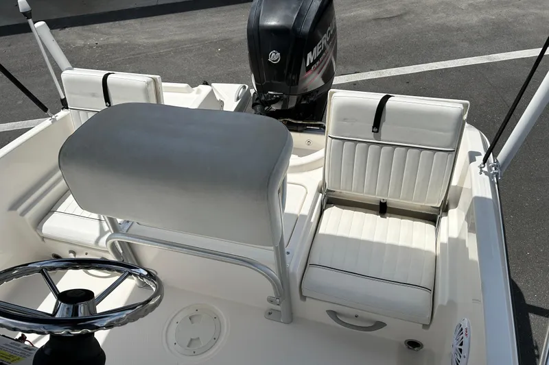 Slide: The Image of 2018 Bayliner Element F16 boat interior with white seating and steering wheel. - 12