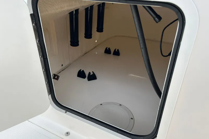 Slide: The Image of Storage compartment inside a 2018 Bayliner Element F16 boat, showing rod holders and wiring. - 15