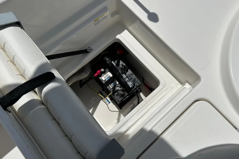 Slide: The Image of 2018 Bayliner Element F16 boat battery compartment with visible wiring and secure hatch. - 17