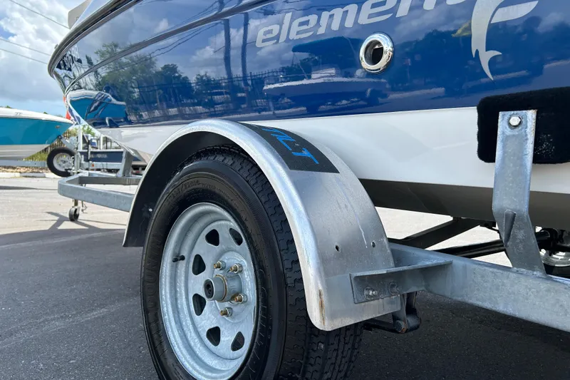 Slide: The Image of 2018 Bayliner Element F16 boat on trailer, close-up of wheel and hull. - 19