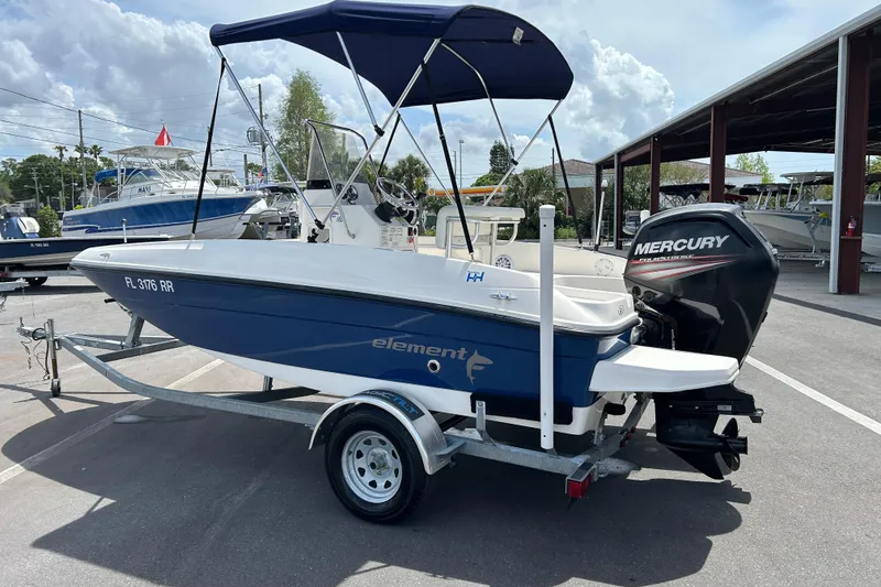 Slide: The Image of 2018 Bayliner Element F16 boat with Mercury engine on trailer, parked outdoors. - 4
