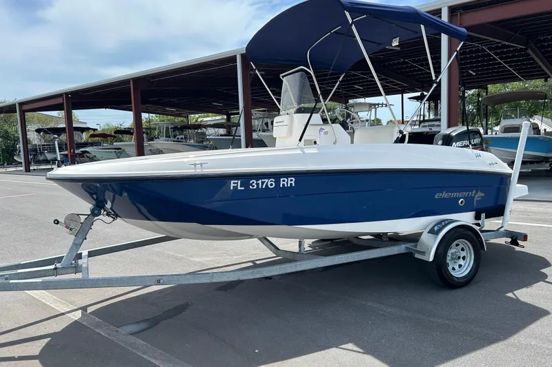 Slide: The Image of 2018 Bayliner Element F16 boat on trailer with blue hull and canopy. - 5