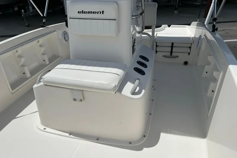 Slide: The Image of 2018 Bayliner Element F16 boat interior with white seating and storage compartments. - 9
