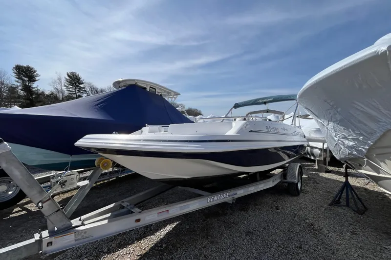 The Image of 2015 Hurricane SunDeck Sport 201 OB boat on trailer, parked outdoors under clear sky. - 0