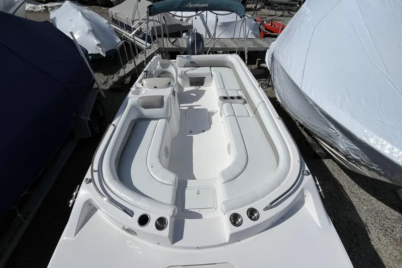 Slide: The Image of 2015 Hurricane SunDeck Sport 201 OB boat, white interior, docked with covers. - 13