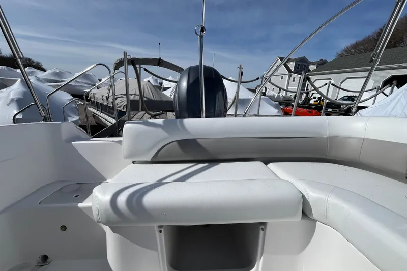 Slide: The Image of 2015 Hurricane SunDeck Sport 201 OB boat interior with white seating and outdoor storage. - 19
