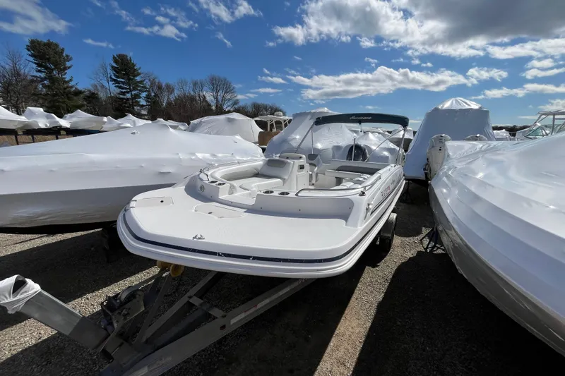 Slide: The Image of 2015 Hurricane SunDeck Sport 201 OB boat on trailer under blue sky. - 2