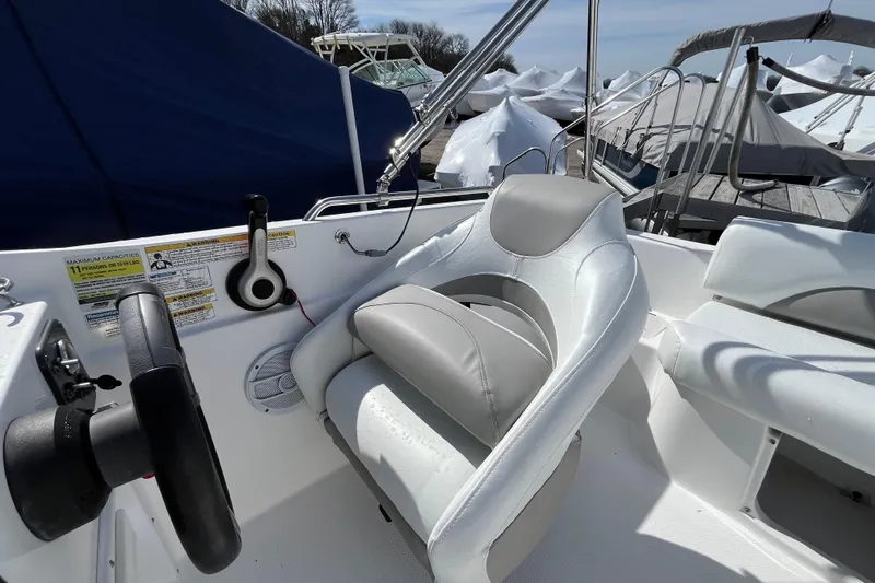 Slide: The Image of 2015 Hurricane SunDeck Sport 201 OB boat interior with steering wheel and seating. - 23
