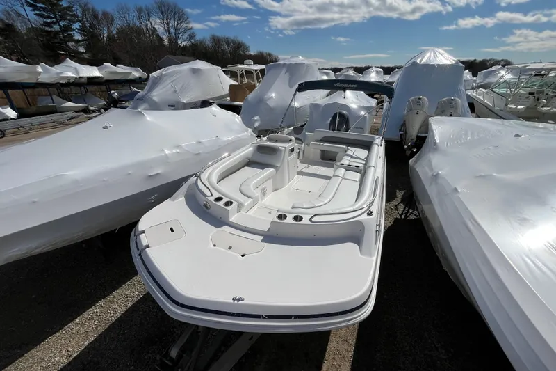 Slide: The Image of 2015 Hurricane SunDeck Sport 201 OB boat in storage, surrounded by covered boats. - 3
