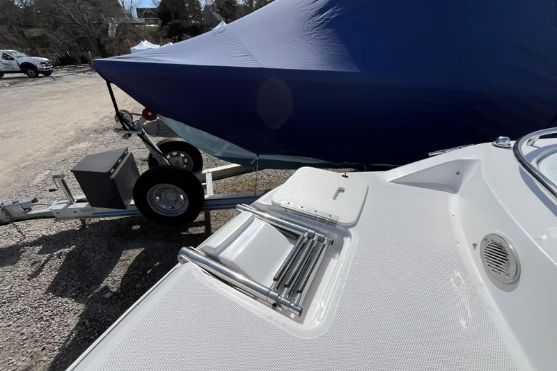 Slide: The Image of 2015 Hurricane SunDeck Sport 201 OB boat on trailer, covered with blue tarp. - 30