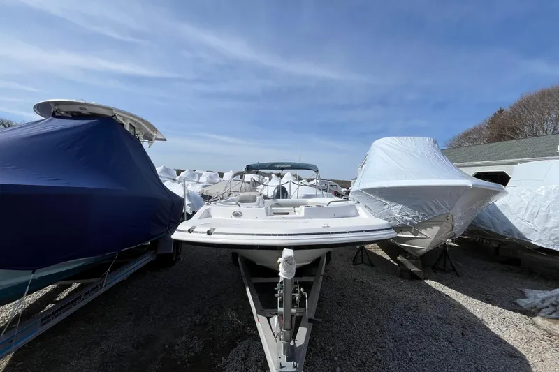 Slide: The Image of 2015 Hurricane SunDeck Sport 201 OB boat stored outdoors, surrounded by covered boats. - 4