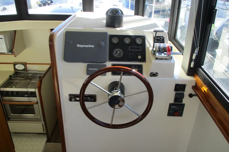 Slide: The Image of 2005 Camano Troll Flybridge helm with Raymarine equipment and kitchen view. - 20