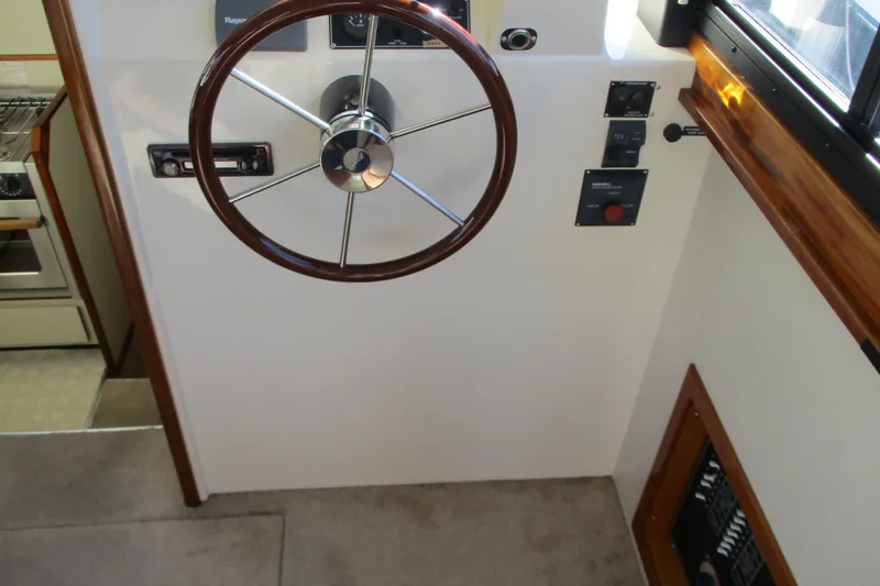 Slide: The Image of 2005 Camano Troll Flybridge helm with wooden steering wheel and control panel. - 22