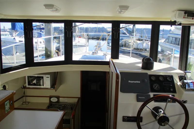 Slide: The Image of Interior view of 2005 Camano Troll Flybridge boat with steering wheel and navigation equipment. - 23
