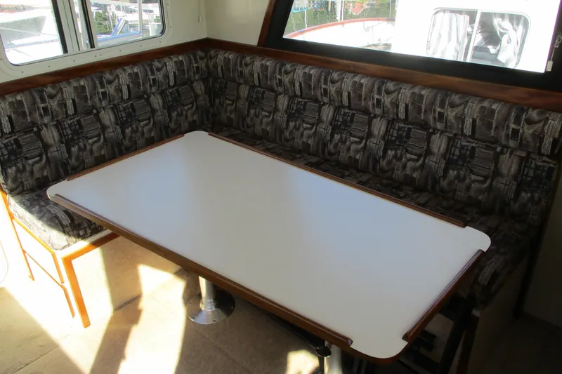 Slide: The Image of 2005 Camano Troll Flybridge interior with patterned seating and a white table. - 27
