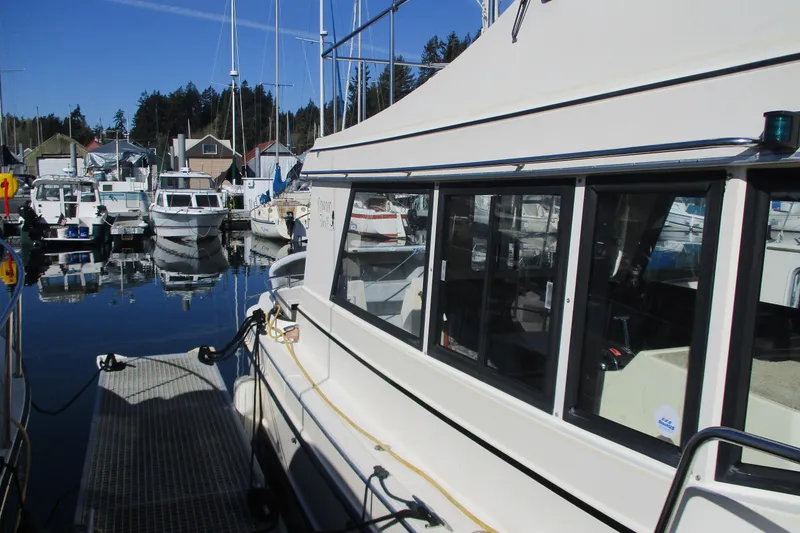 Slide: The Image of 2005 Camano Troll Flybridge docked at marina with other boats. - 4
