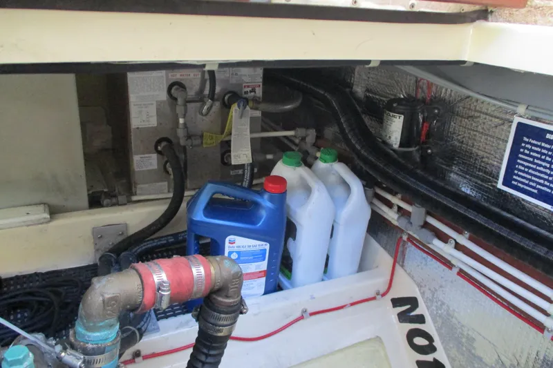 Slide: The Image of Engine compartment of 2005 Camano Troll Flybridge with fluid containers and piping. - 48