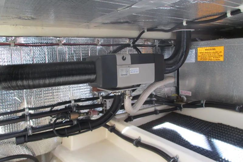 Slide: The Image of Engine room of 2005 Camano Troll Flybridge with insulated pipes and warning labels. - 50