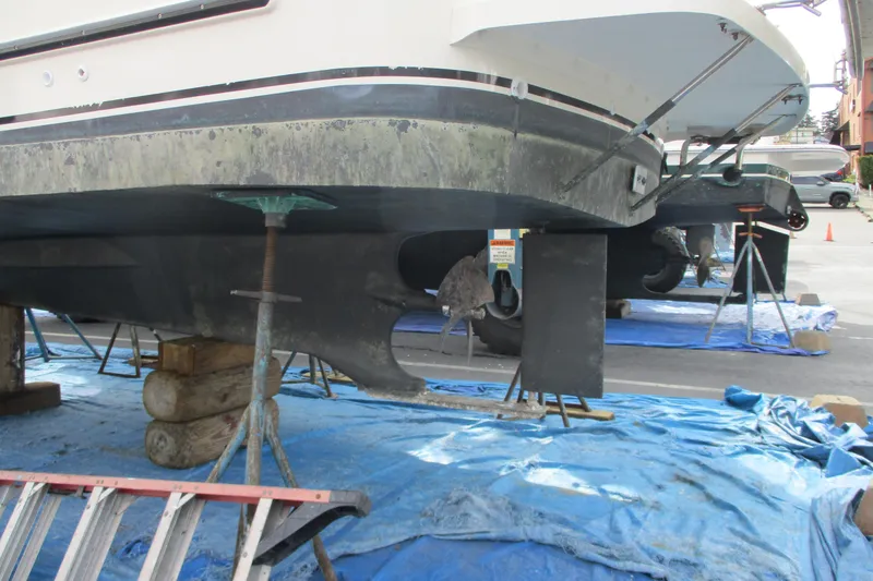 Slide: The Image of 2005 Camano Troll Flybridge boat on stands for maintenance, hull exposed. - 52