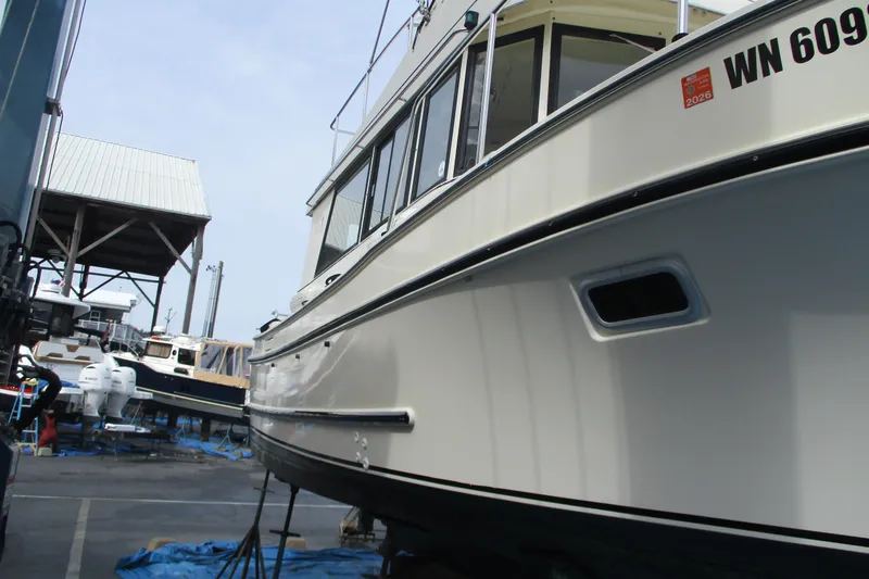 Slide: The Image of 2005 Camano Troll Flybridge boat in dry dock, side view with registration visible. - 56