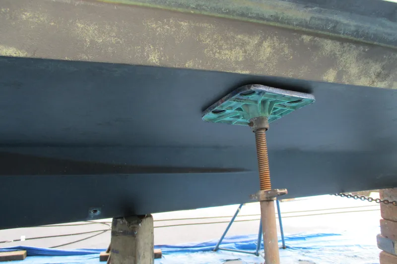 Slide: The Image of 2005 Camano Troll Flybridge boat hull supported by a jack stand. - 62