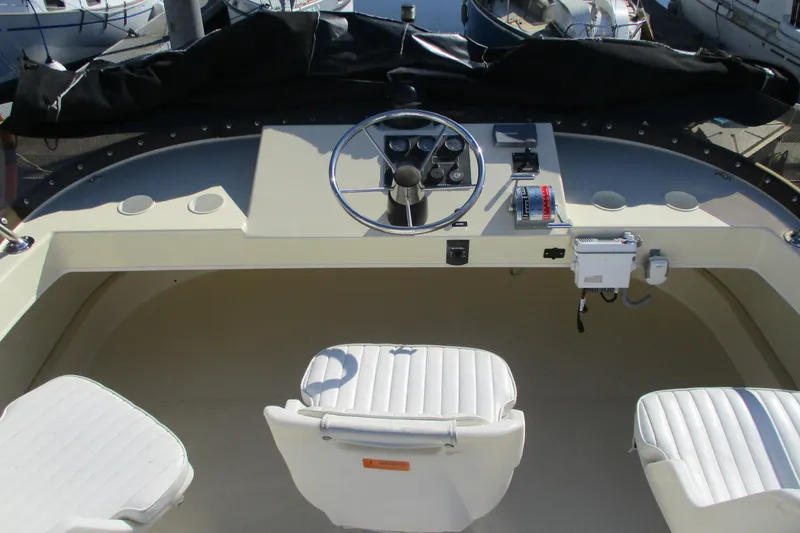 Slide: The Image of 2005 Camano Troll Flybridge helm with steering wheel and white seating. - 8