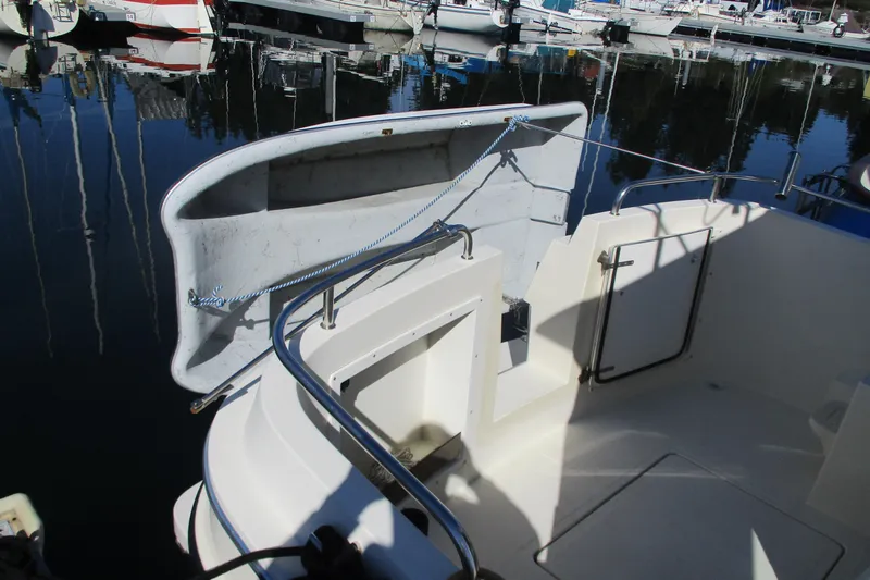 Slide: The Image of 2005 Camano Troll Flybridge boat docked at marina, featuring open deck and railing. - 14