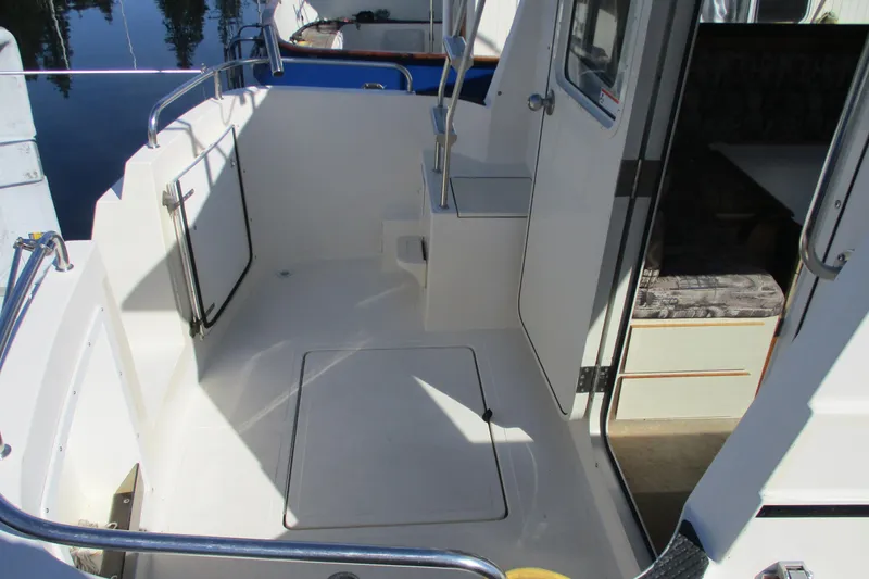 Slide: The Image of 2005 Camano Troll Flybridge boat deck with open door and seating area. - 17