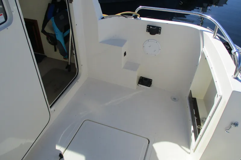 Slide: The Image of 2005 Camano Troll Flybridge boat interior with open door and storage compartments. - 19