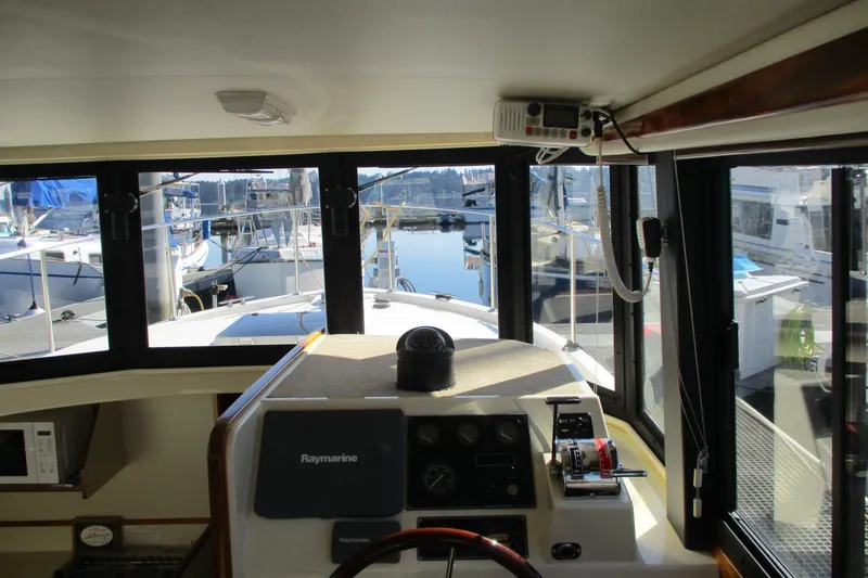 Slide: The Image of Interior view of 2005 Camano Troll Flybridge boat with marina in background. - 28