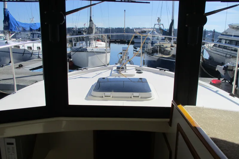 Slide: The Image of Interior view from a 2005 Camano Troll Flybridge, overlooking a marina with docked boats. - 30