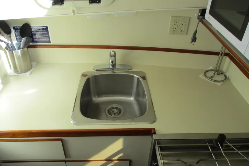 Slide: The Image of 2005 Camano Troll Flybridge kitchen sink with utensils and microwave. - 32