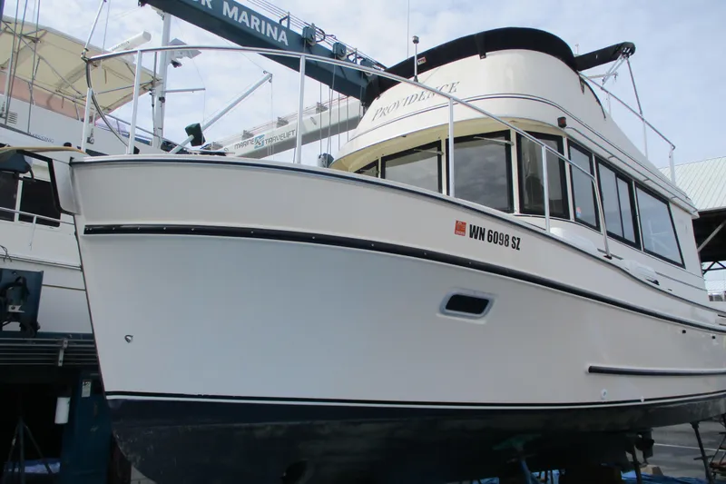 Slide: The Image of 2005 Camano Troll Flybridge boat docked at a marina, side view. - 51
