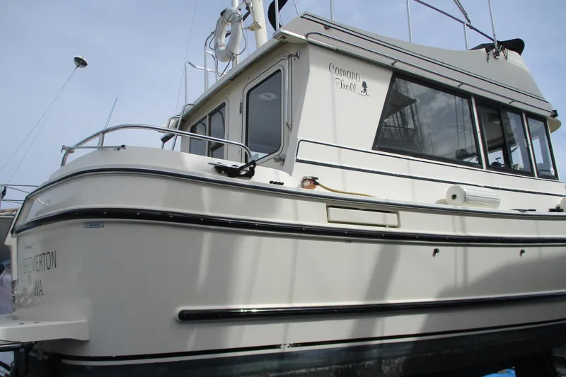 Slide: The Image of 2005 Camano Troll Flybridge boat with white exterior and sleek design. - 54