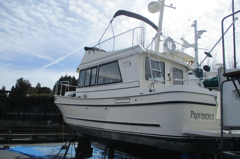 Slide: The Image of 2005 Camano Troll Flybridge boat on dry dock under a cloudy sky. - 59