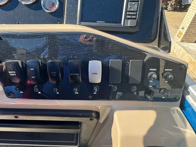 Slide: The Image of 2026 SunCatcher Select 20F boat dashboard with control switches. - 12