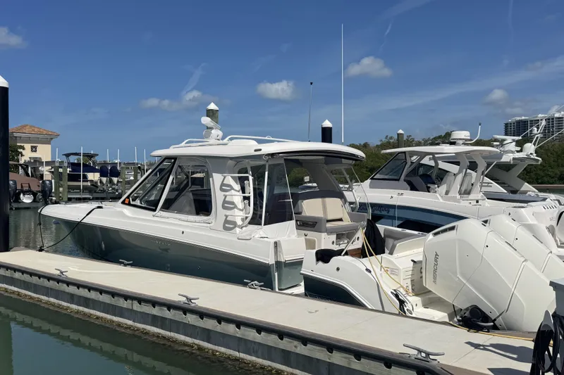 Slide: The Image of 2024 Boston Whaler 380 Realm docked, showcasing sleek design and powerful engines. - 1