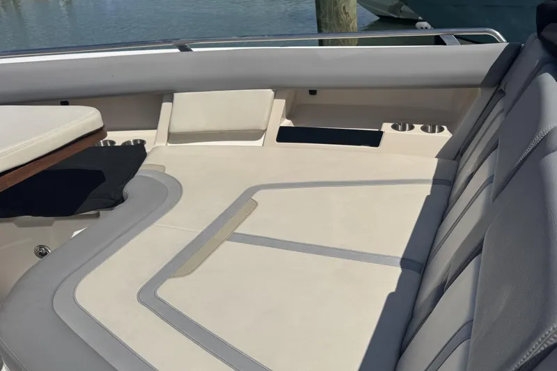 Slide: The Image of 2024 Boston Whaler 380 Realm boat interior with cushioned seating and cup holders. - 14